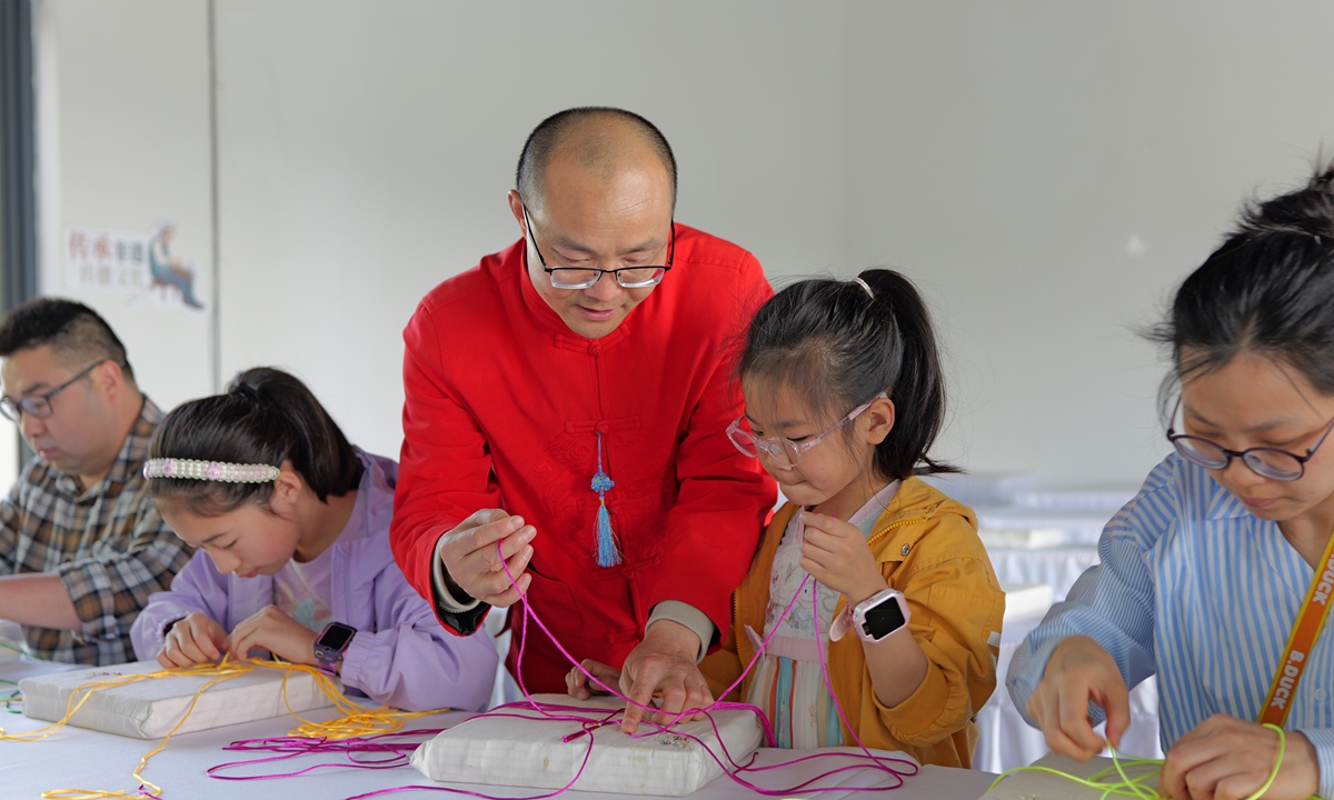 Rural craftsman Yang Wenyi (center) teaches students in Xinjin, Southwest China's Sichuan Province. 
Photo: Courtesy of Yang Wenyi