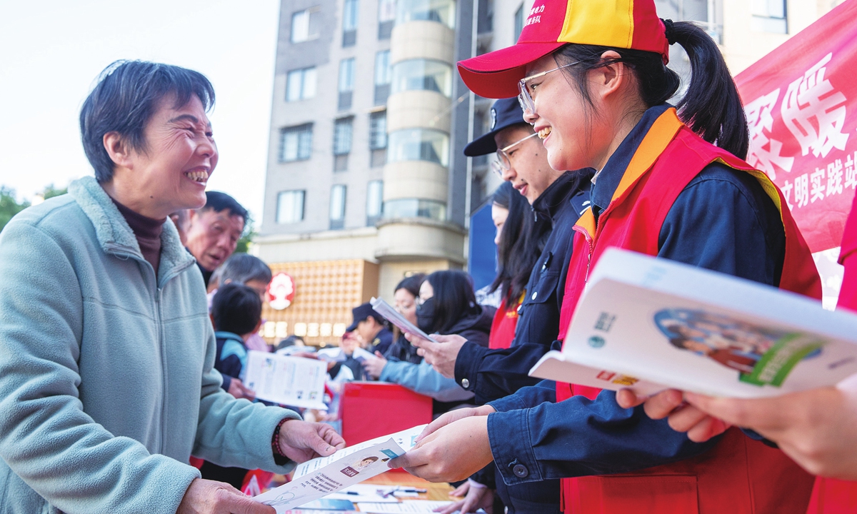 Party member volunteers from a power supply company in Xiuning, East China's Anhui Province discuss with local community residents the winter appliance safety and energy-saving tips on November 21, 2025. Photo: VCG