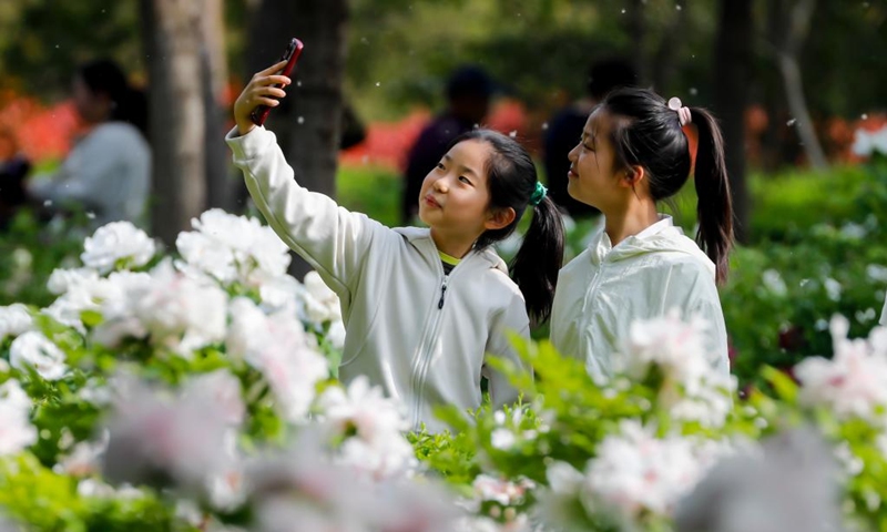 Children pose for selfies at a park in Wuzhi County, central China's Henan Province, April 11, 2026. (Photo by Wang Linfeng/Xinhua)