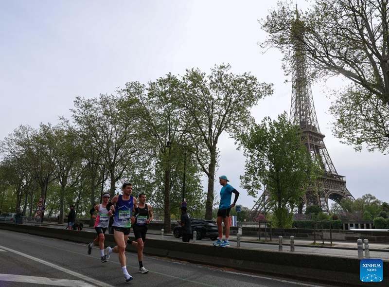 Participants run past the Eiffel Tower during the Paris Marathon 2026 in Paris, France, April 12, 2026. (Xinhua/Wu Huiwo)