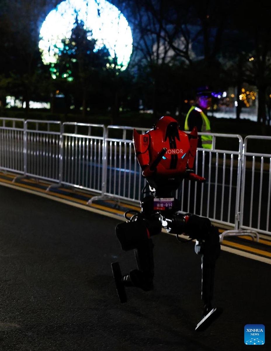 A humanoid robot from remote control team runs during the test activity for the 2026 Beijing E-Town Humanoid Robot Half Marathon on April 11, 2026. A full-process and comprehensive testing activity for the Beijing E-Town humanoid robot half-marathon, scheduled for April 19, 2026, was carried out from Saturday night to early Sunday morning. (Xinhua/Wang Lili)
