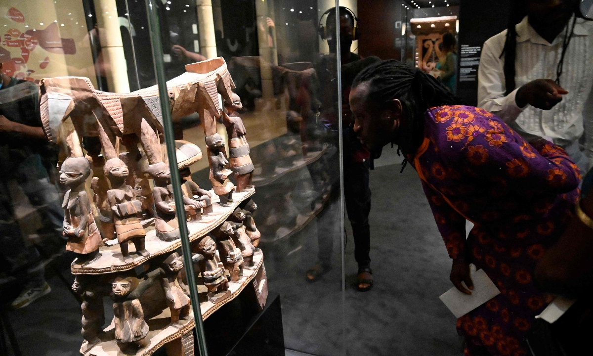 A visitor examines the Cana throne, which was looted by French colonial soldiers, at an exhibition featuring both returned Benin artefacts and contemporary artworks in Cotonou, Benin, on February 18, 2022. Photo: VCG