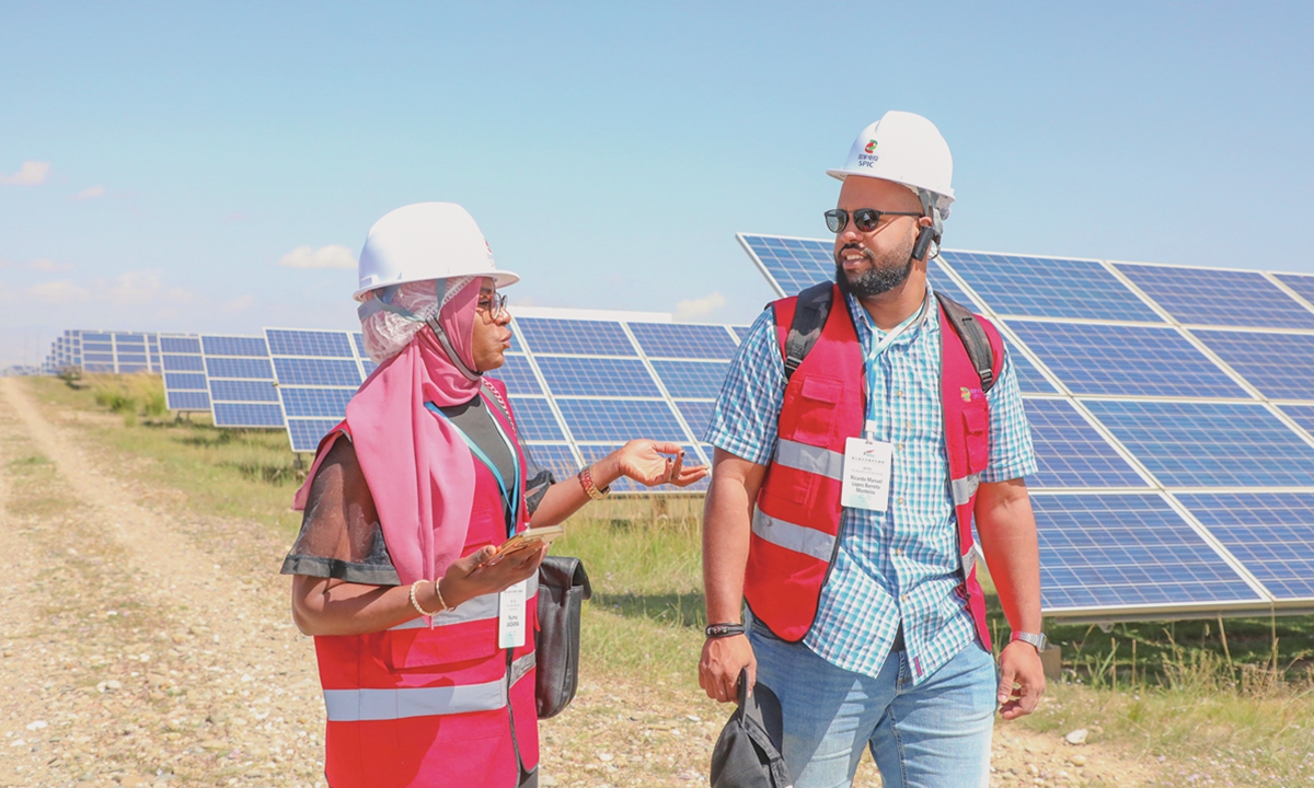 Deux jeunes délégués africains visitent un parc de production d'énergie photovolta?que dans le désert de Talatan Gobi, province du Qinghai, nord-ouest de la Chine, le 12 septembre 2025. Photo : IC