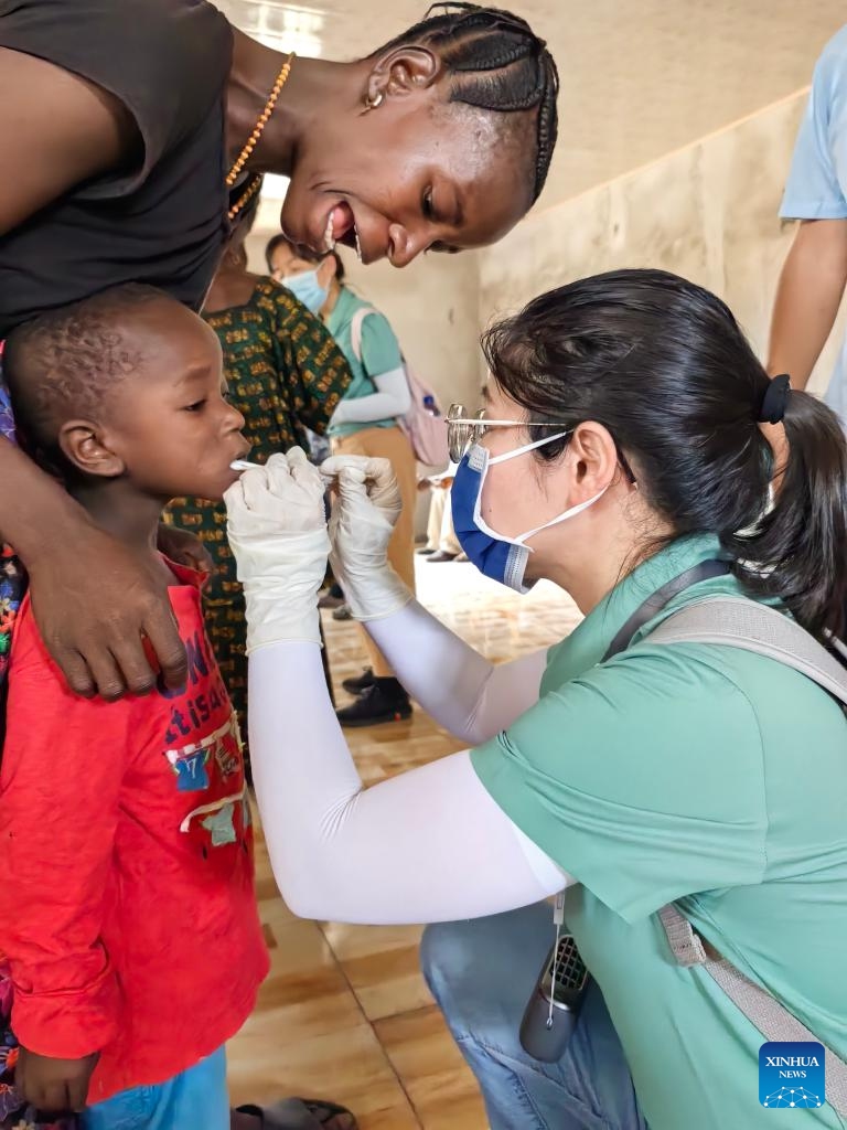 A member of the 27th batch of the Chinese medical team in Sierra Leone provides oral examination for a child in Rokel Village in the North West Province, Sierra Leone, April 12, 2026.(The 27th batch of the Chinese medical team in Sierra Leone/Handout via Xinhua)
