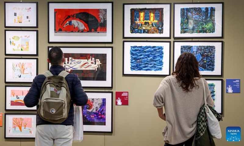Visitors watch the illustrations during the 63rd Bologna Children's Book Fair in Bologna, Italy, April 13, 2026. The 63rd Bologna Children's Book Fair opened on Monday in the Italian city of Bologna. (Xinhua/Wang Kaiyan)

