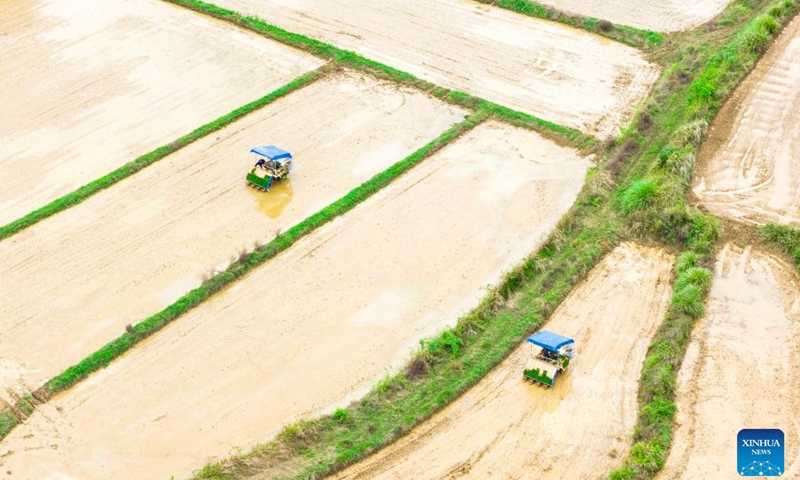 An aerial drone photo taken on April 9, 2026 shows agricultural machines at work in Xiqiao Village of Duchang County, Jiujiang, east China's Jiangxi Province. (Photo by Fu Jianbin/Xinhua)

