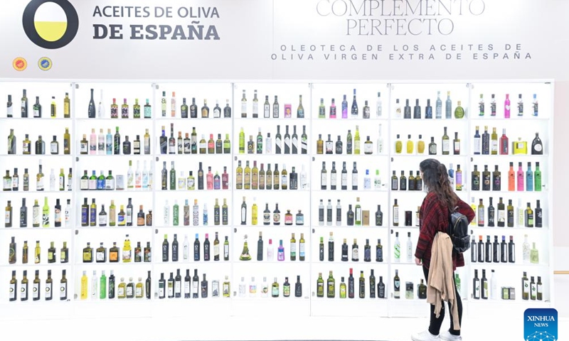 A woman stands next to an olive oil stand during the Salon Gourmets in Madrid, Spain, on April 13, 2026. The 39th Salon Gourmets will run in Madrid from April 13 to 16. (Photo by Gustavo Valiente/Xinhua)