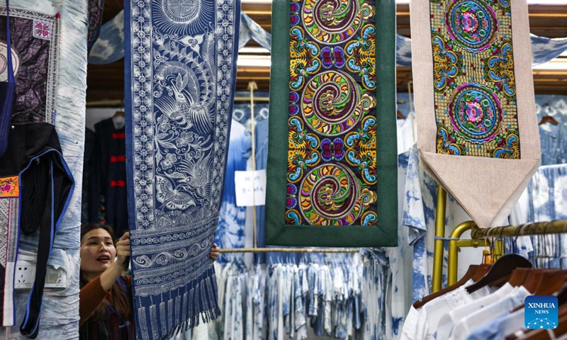 A woman from Dong ethnic group arranges an indigo dyed fabric and embroidery works in Zhaoxing Dong Village of Liping County, southwest China's Guizhou Province, April 21, 2026.

