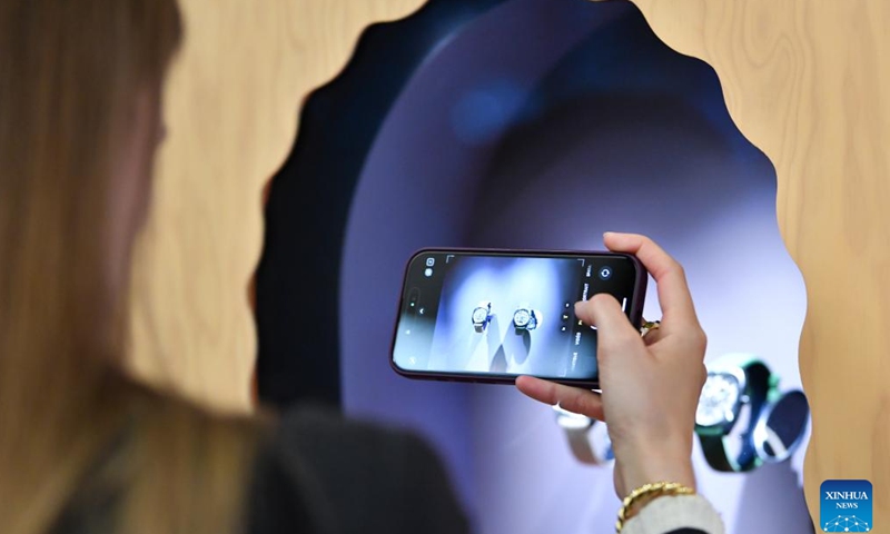 A visitor takes a photo of exhibits during the Watches and Wonders Geneva 2026 at the Palexpo in Geneva, Switzerland, April 14, 2026. The 7-day event kicked off here on Tuesday, bringing together 65 participating brands. (Xinhua/Lian Yi)

