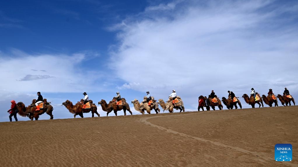 Tourists visit the Mingsha Mountain and Crescent Spring Scenic Area in Dunhuang City, northwest China's Gansu Province, April 27, 2026. As the May Day holiday approaches, the tourism markets across the country are heating up. (Photo by Zhang Xiaoliang/Xinhua)

