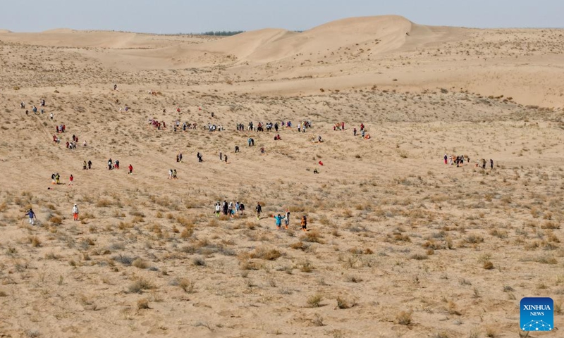A drone photo shows volunteers planting trees at the Zhonglin ecological public welfare forest base of Minqin County, northwest China's Gansu Province, April 21, 2026.

