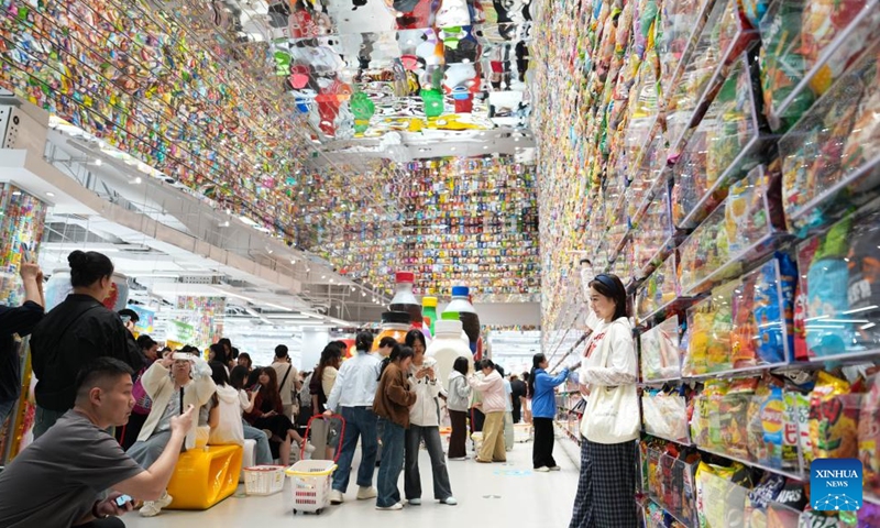 People take photos at a large snack store in Changsha, central China's Hunan Province, April 17, 2026. A large-scale snack store covering 12,000 square meters opened in Changsha on Friday. Housing more than 6,500 brands and over 35,000 products, the store offers consumers an exploratory experience incorporating shopping, social media engagement, and interactive activities. (Xinhua/Chen Zhenhai)

