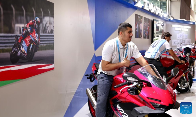 Visitors pose for photos with products of Chinese motorcycle maker ZXMOTO at the 139th edition of the China Import and Export Fair in Guangzhou, south China's Guangdong Province, April 17, 2026. The recent historic double victory by Chinese motorcycle maker ZXMOTO in the World Supersport category at the Portuguese round of the Superbike World Championship has drawn widespread attention. (Xinhua/Lu Hanxin)

