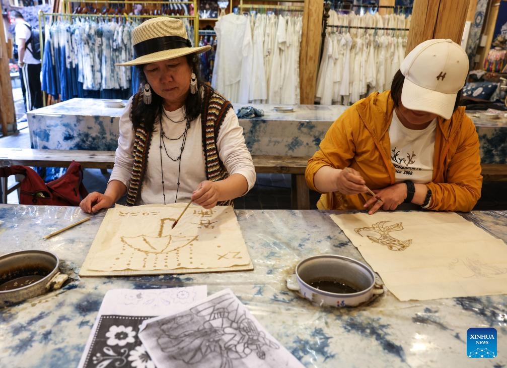 Tourists draw patterns on fabrics in Zhaoxing Dong Village of Liping County, southwest China's Guizhou Province, April 20, 2026.

