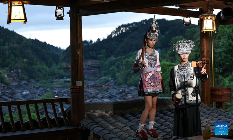 Tourists take photos at a cafe in Zhaoxing Dong Village of Liping County, southwest China's Guizhou Province, April 20, 2026.

