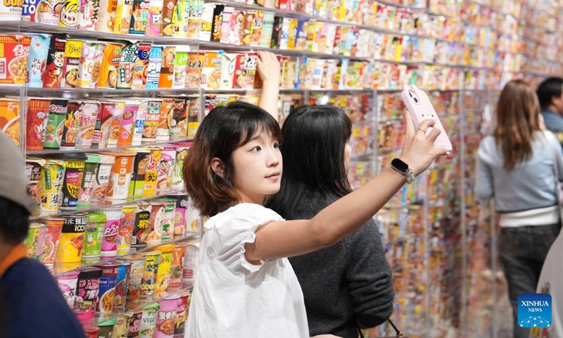 A person takes a selfie at a large snack store in Changsha, central China's Hunan Province, April 17, 2026. A large-scale snack store covering 12,000 square meters opened in Changsha on Friday. Housing more than 6,500 brands and over 35,000 products, the store offers consumers an exploratory experience incorporating shopping, social media engagement, and interactive activities. (Xinhua/Chen Zhenhai)

