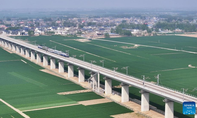 This aerial drone photo taken on April 15, 2026 shows a test train passing through a bridge along the Xiong'an-Shangqiu High-speed Railway in north China's Hebei Province.(Photo by Wang Guansheng/Xinhua)