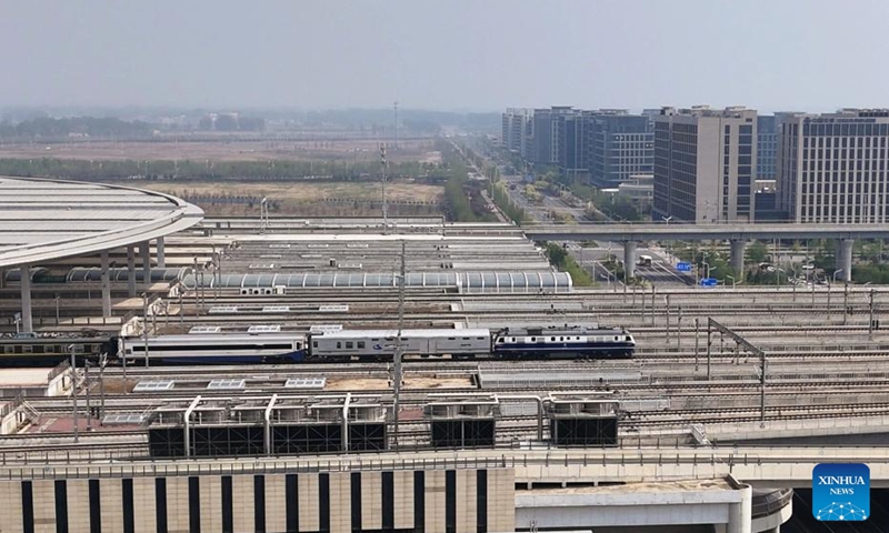 This aerial drone photo taken on April 15, 2026 shows a test train departing from Xiong'an Railway Station in the Xiong'an New Area, north China's Hebei Province. (Photo by Lu Qifan/Xinhua)