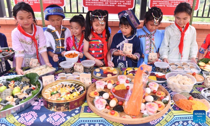 Students display delicacies at a primary school in Changzhou District of Wuzhou City, south China's Guangxi Zhuang Autonomous Region, April 15, 2026. The Sanyuesan Festival is a traditional festival celebrated on the third day of the third lunar month by various ethnic groups in China, which falls on April 19 this year. (Xinhua/Huang Xiaobang)