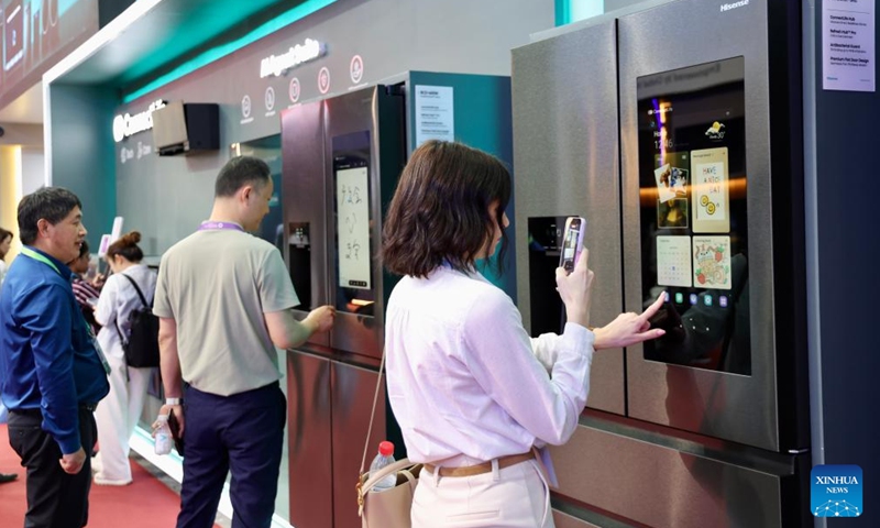 A visitor (front) learns about a smart refrigerator during the 139th edition of the China Import and Export Fair in Guangzhou, south China's Guangdong Province, April 15, 2026. (Xinhua/Lu Hanxin)