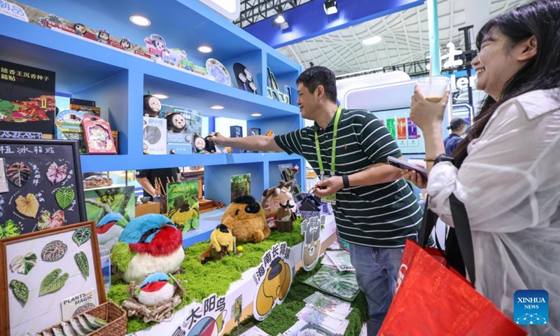 People look at cultural and creative products during the sixth China International Consumer Products Expo (CICPE) in Haikou, south China's Hainan Province, April 14, 2026. From intangible cultural heritage skills to original IPs with traditional Chinese cultural characteristics, Chinese brands blend tradition with modernity and showcase their charm at the ongoing CICPE, attracting the attention of many visitors. (Xinhua/Zhang Liyun)