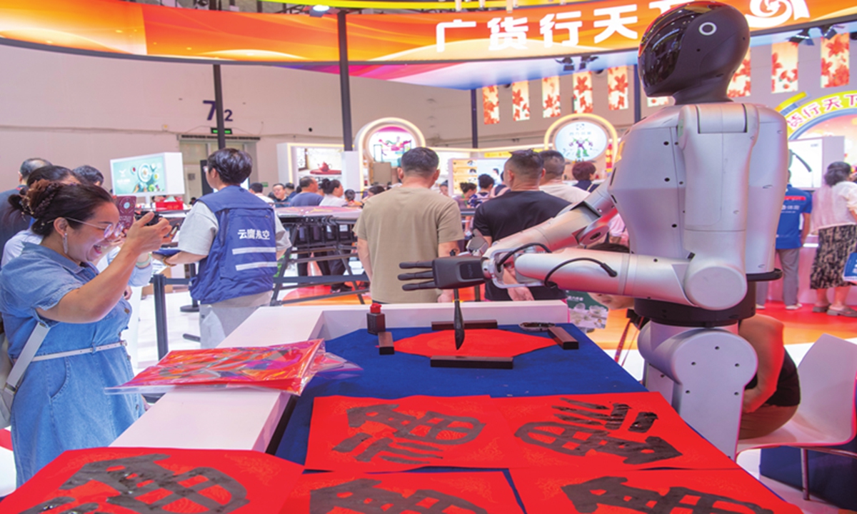 Visitors watch a robot writing calligraphy at the Sixth China International Consumer Products Expo in Haikou, South China's Hainan Province, on April 16, 2026. Photo: VCG