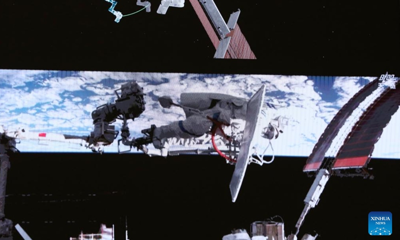 This screen image captured at Beijing Aerospace Control Center on April 16, 2026 shows Shenzhou-21 taikonaut Wu Fei performing extravehicular activities (EVAs) outside China's orbiting space station. (Photo by Zhang Fan/Xinhua)