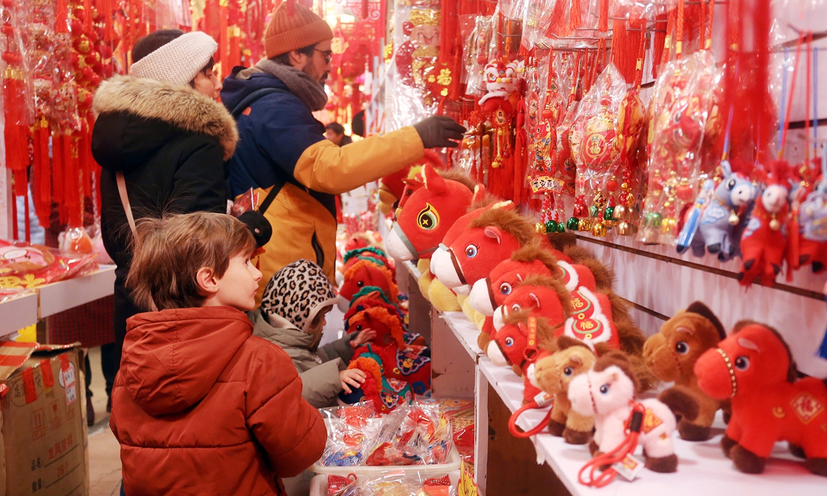 Foreign visitors select dolls featuring Chinese Year of the Horse zodiac elements at a tourist commodity market in Shanghai on February 11, 2026. Photo: VCG