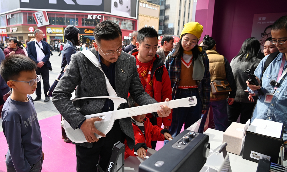 A visitor tries a stringless guitar at an AI technology exhibition in Chengdu, Sichuan Province, on February 14, 2026. Photo: VCG
