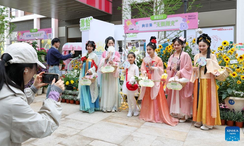 Tourists pose for photos at a flower fair in Huangpu District of Shanghai, east China, April 18, 2026. The 2026 Shanghai International Flower Show opened on Saturday with events in two main venues, 10 sub-venues and multiple exhibition spots across the city. (Xinhua/Chen Haoming)