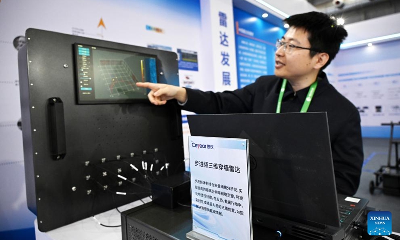 A staff member explains the working principle of a wall-penetrating radar during the 6th Radar Future Conference in Qingdao, east China's Shandong Province, on April 18, 2026. The conference opened here on Saturday and will run till April 20, showcasing the latest radar-related technologies and products. (Xinhua/Li Ziheng)
