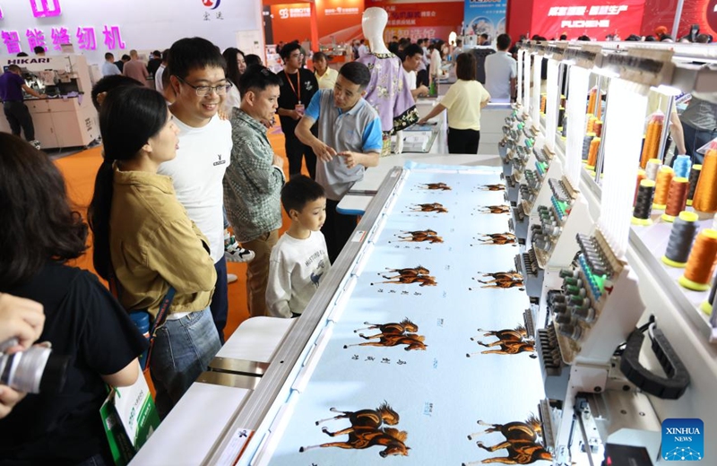 Visitors learn about intelligent textile machines during the 28th Straits Textile and Clothing Fair in Shishi, southeast China's Fujian Province, April 18, 2026. The fair kicked off here on Saturday. (Xinhua/Jiang Kehong)