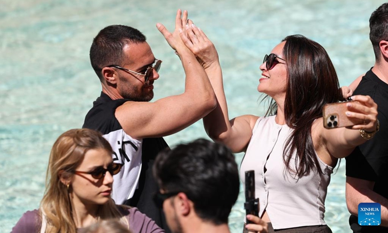 Tourists toss a coin to make a wish at the Trevi Fountain in Rome, Italy, April 17, 2026. (Xinhua/Li Jing)