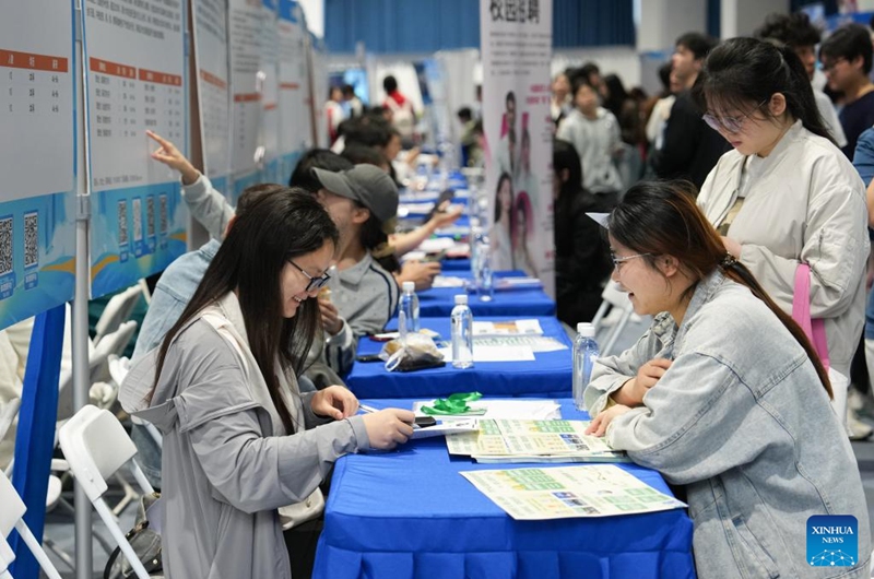 A job seeker (R) talks with a recruiter at a job fair held at Hunan Normal University in Changsha, central China's Hunan Province, April 18, 2026. The two-day job fair for university graduates kicked off on Saturday, with the main venues in Hunan University and Hunan Normal University. (Xinhua/Chen Zhenhai)