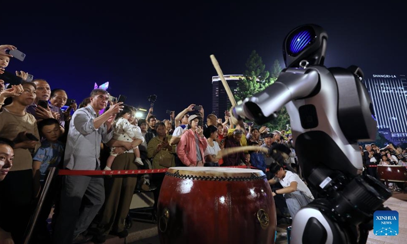 People watch a robot dance performance in Fuzhou, southeast China's Fujian Province, April 19, 2026. A robot dance performance was staged here to welcome the 9th Digital China Summit, which will convene in Fuzhou from April 29 to 30. (Xinhua/Jiang Kehong)

