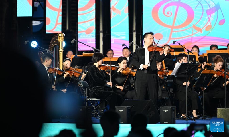 Members of Tianjin Symphony Orchestra perform at the Jinwan Square by the Haihe River in north China's Tianjin, April 18, 2026. 