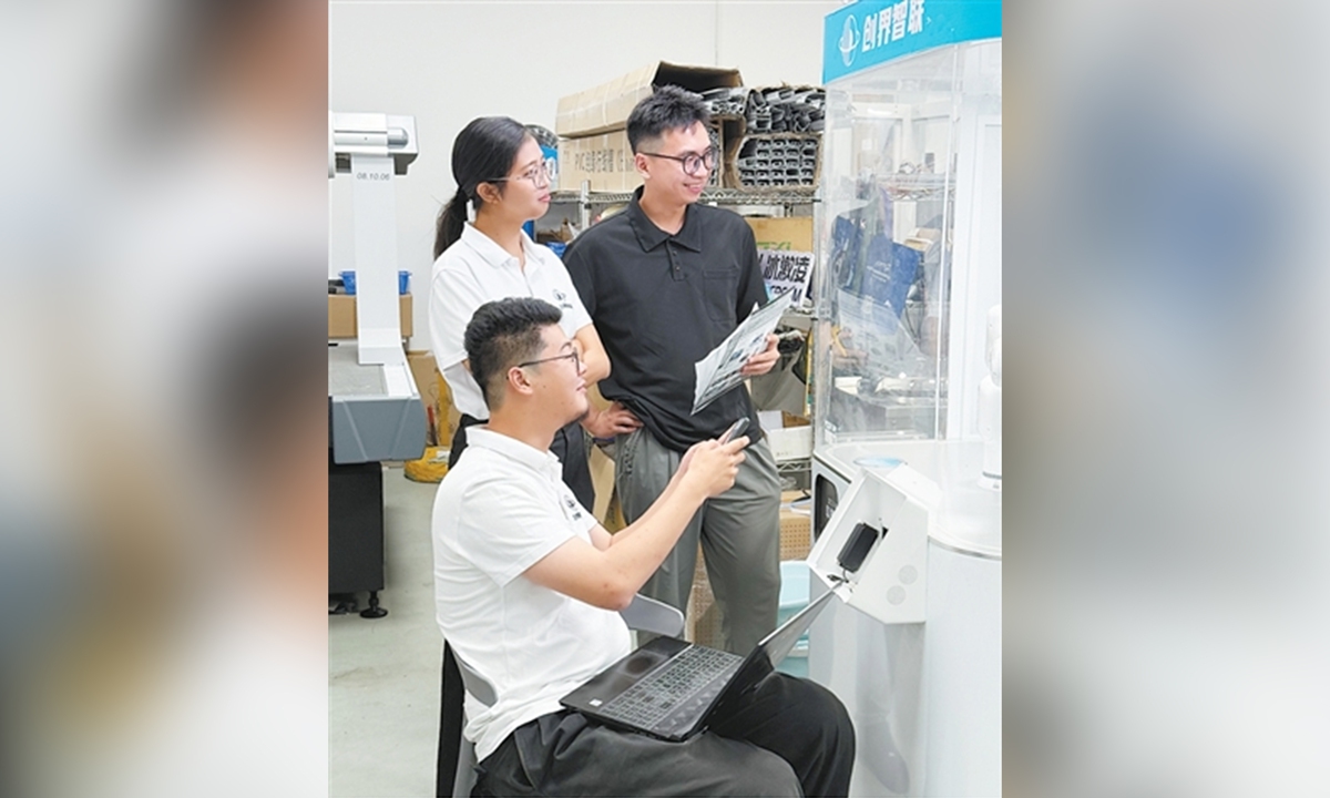 Lun Wenjing (middle) and her colleagues test an ice cream robot. Photo: Lin Junrun