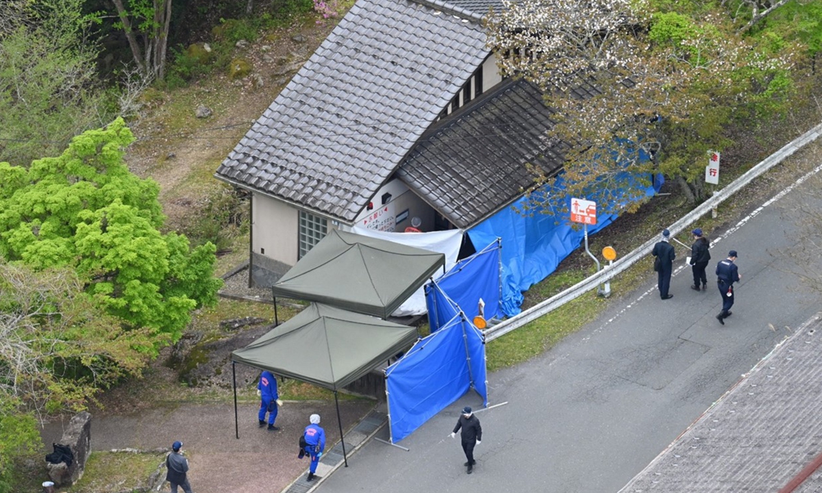 An aerial photo shows Kyoto Prefectural Police investigators searching near a public restroom at Kyoto Prefectural Rurikei Nature Park, a tourist spot, following a child abandonment case in Nantan City, Kyoto Prefecture, Japan, on April 18, 2026.  Photo: VCG