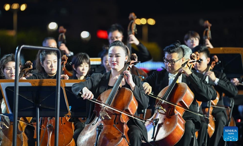 Members of Tianjin Symphony Orchestra perform at the Jinwan Square by the Haihe River in north China's Tianjin, April 18, 2026. 