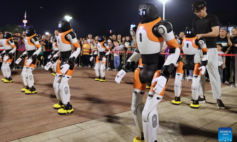 A staff member adjusts robots before their dance performance in Fuzhou, southeast China's Fujian Province, April 19, 2026. A robot dance performance was staged here to welcome the 9th Digital China Summit, which will convene in Fuzhou from April 29 to 30. (Xinhua/Jiang Kehong)

