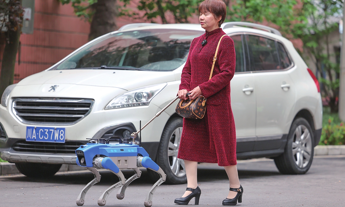 A visually impaired person tests an all-terrain smart guide dog in Chengdu, Southwest China's Sichuan Province on April 21, 2026. This robot navigates slopes, uneven roads, and stairs. Featuring HD voice interaction, it supports daily activities such as commuting, shopping, and hospital visits, empowering users with independence through advanced environmental perception and mobility. Photo: VCG