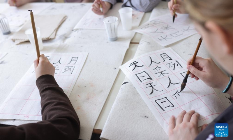 Students participate in a Chinese calligraphy workshop during an event marking the International Chinese Language Day at a high school in Celje, Slovenia, April 20, 2026. (Photo by Zeljko Stevanic/Xinhua)

