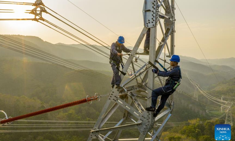 A drone photo shows technicians inspecting a section of power transmission line of the China-Laos 500-kV interconnection project in Xishuangbanna Dai Autonomous Prefecture, southwest China's Yunnan Province, April 14, 2026.

