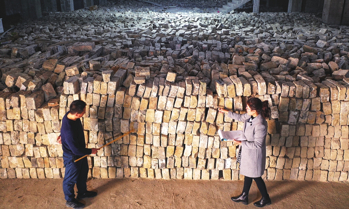 Experts examine bricks from the city wall. Photo: Courtesy of the Nanjing City Wall Protection and Management Center