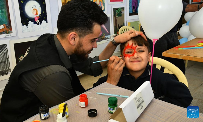 A Syrian child gets his face painted at a book fair at the National Library in Damascus, Syria, April 21, 2026. A book fair featuring activities such as group reading, chess, and painting was held here on Tuesday, aiming to promote reading and cultural awareness among the younger generation. (Photo by Ammar Safarjalani/Xinhua)

