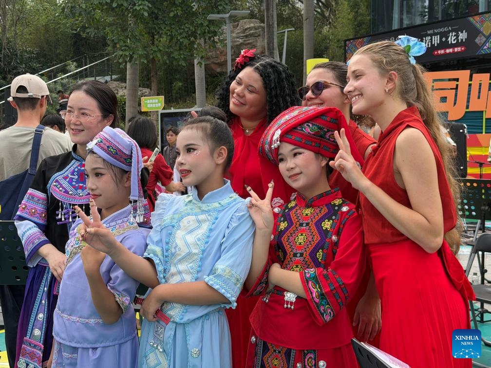 Members of the Copacabana Fort Orchestra pose for photos with children in Chinese ethnic costumes in Nanning, south China's Guangxi Zhuang Autonomous Region, April 17, 2026.(Xinhua/Zhao Huan)


