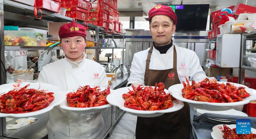 Chefs show cooked crayfish in Xuyi County, east China's Jiangsu Province, March 19, 2026. 