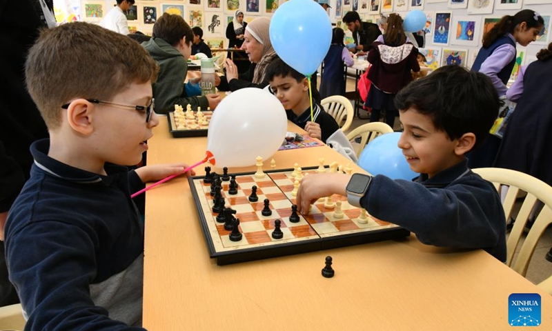 Syrian children play chess at a book fair at the National Library in Damascus, Syria, April 21, 2026. A book fair featuring activities such as group reading, chess, and painting was held here on Tuesday, aiming to promote reading and cultural awareness among the younger generation. (Photo by Ammar Safarjalani/Xinhua)

