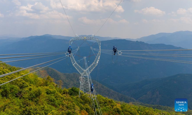 An aerial drone photo shows technicians inspecting a section of power transmission line of the China-Laos 500-kV interconnection project in Xishuangbanna Dai Autonomous Prefecture, southwest China's Yunnan Province, April 14, 2026.

