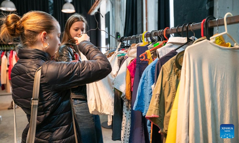People choose clothes at the Swap Festival in Prague, the Czech Republic, April 21, 2026. This year's Swap Festival takes place from April 20 to 26 across multiple locations in Prague, encouraging people to bring items they no longer need such as clothes and books to exchange, promoting repair, reuse, and sharing. (Photo by Dana Kesnerova/Xinhua)

